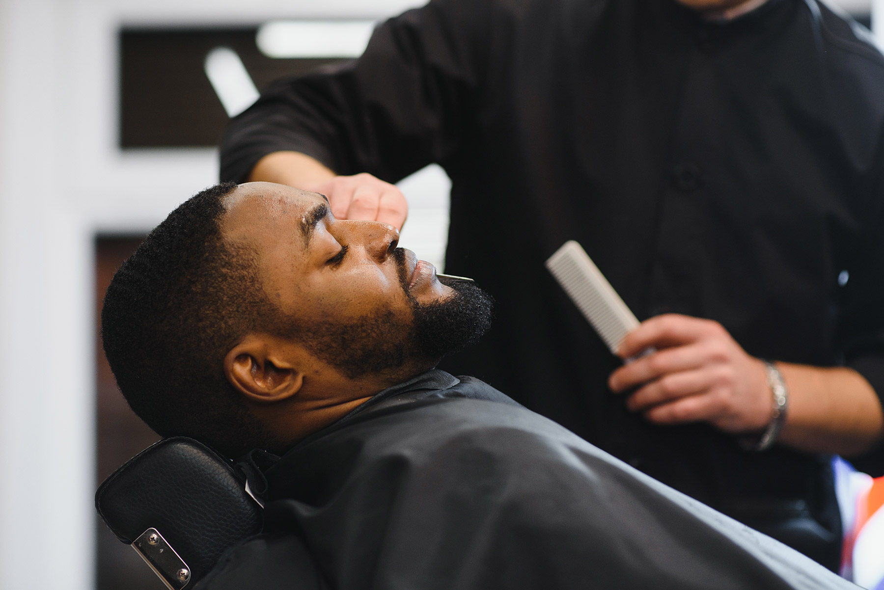 black-man-barbershop-makes-haircut-african-salon